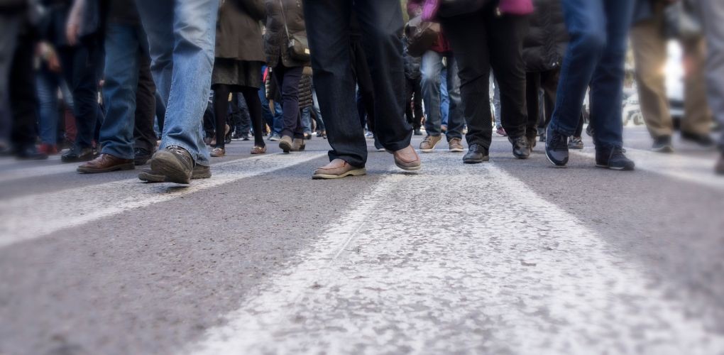 Photo de pieds de personnes qui manifeste dans une rue.